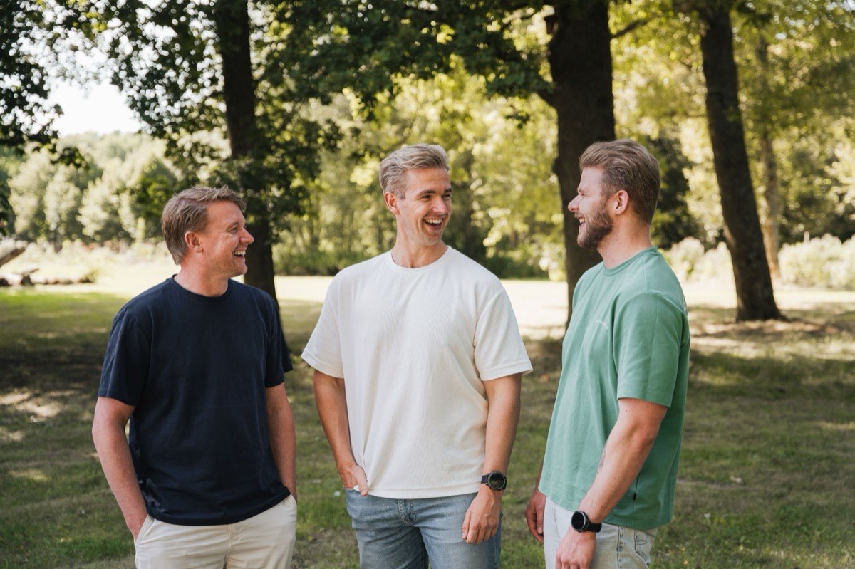 De drie van Empathree buiten in het groen, in gesprek en lachend